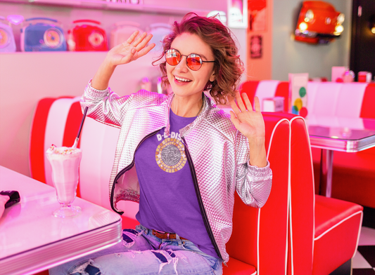 A female wearing a purple tshirt design with a shining disco ball and the text "d-d-disco"