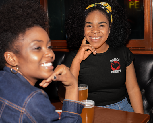 A female wearing a black dance shirt design with a heart on the left side of the torso with the text "dance buddy". A great dance tshirt for social dancing.