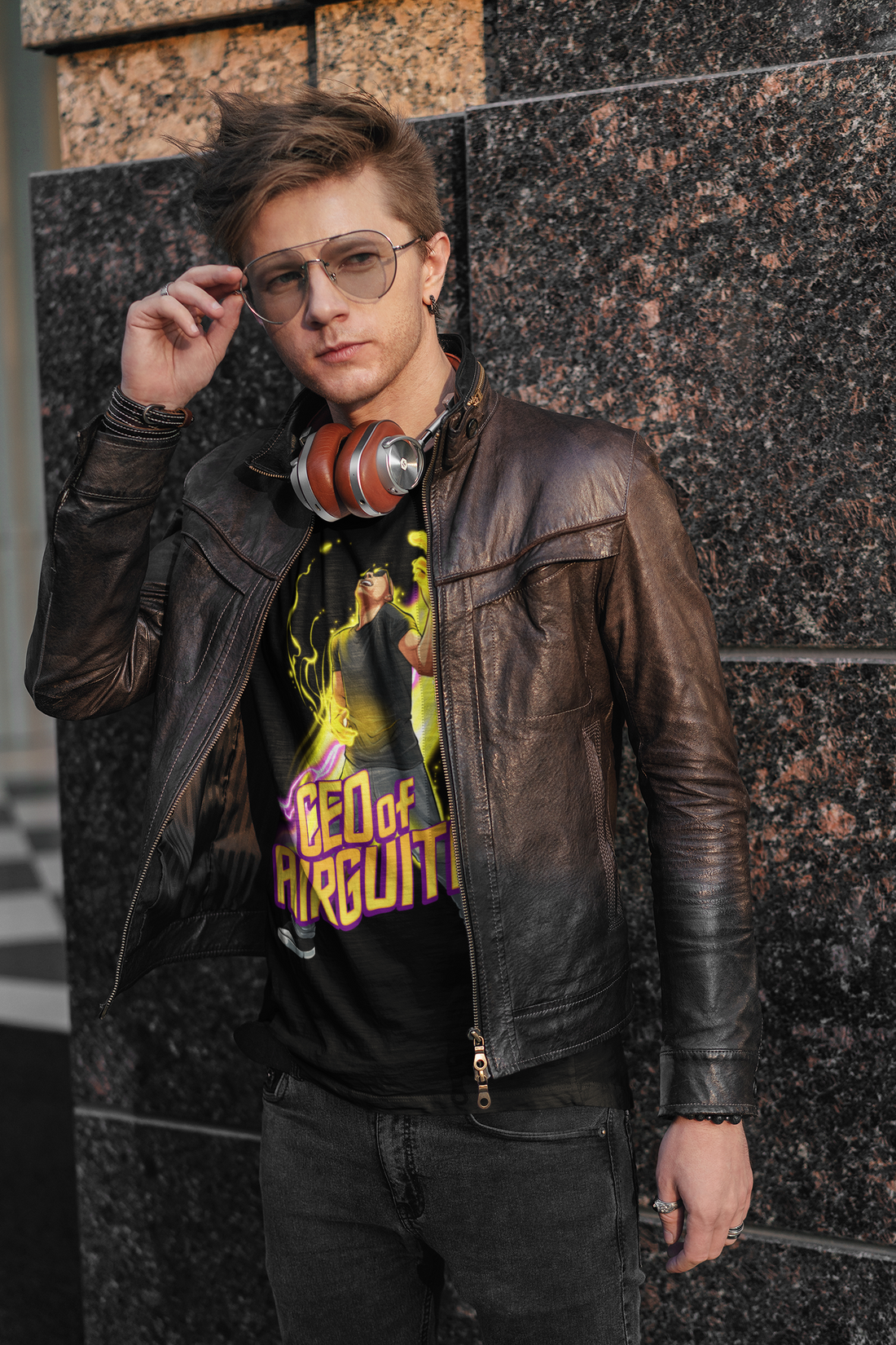 A male wearing a black T-shirt with the text "CEO of air guitar". It has an image of a male playing air guitar and creating magic.