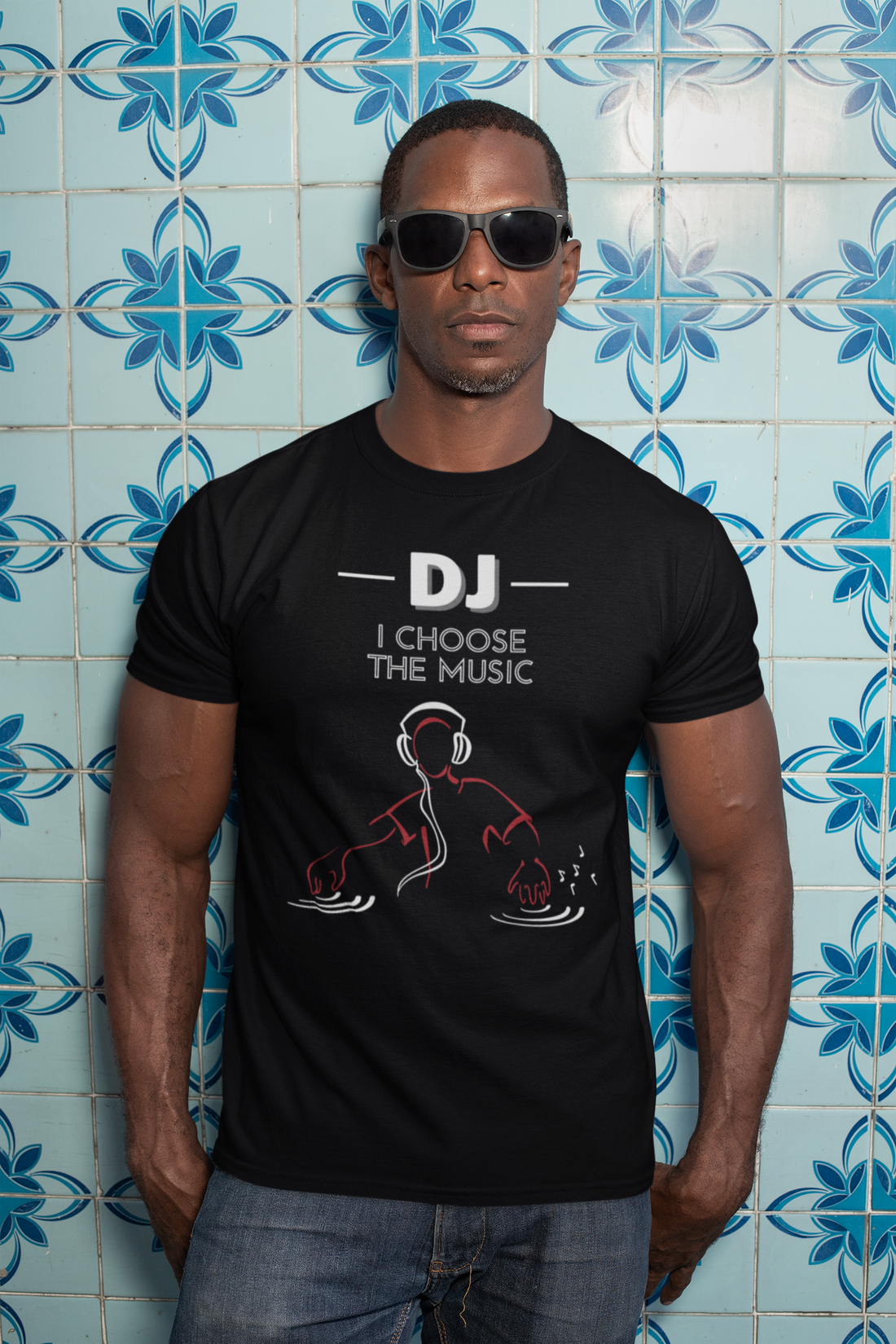 A male wearing a black cool Tshirt design with the text "Dj, I choose the music" with an image of a DJ playing music