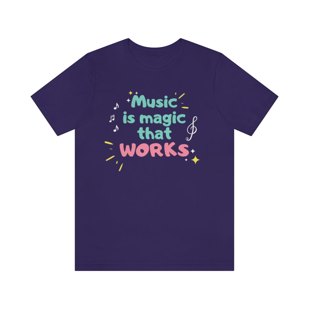 A purple T-shirt with the text "music is magic that works!". It has a childish and playful design with music notes and treble clefs surrounding it.