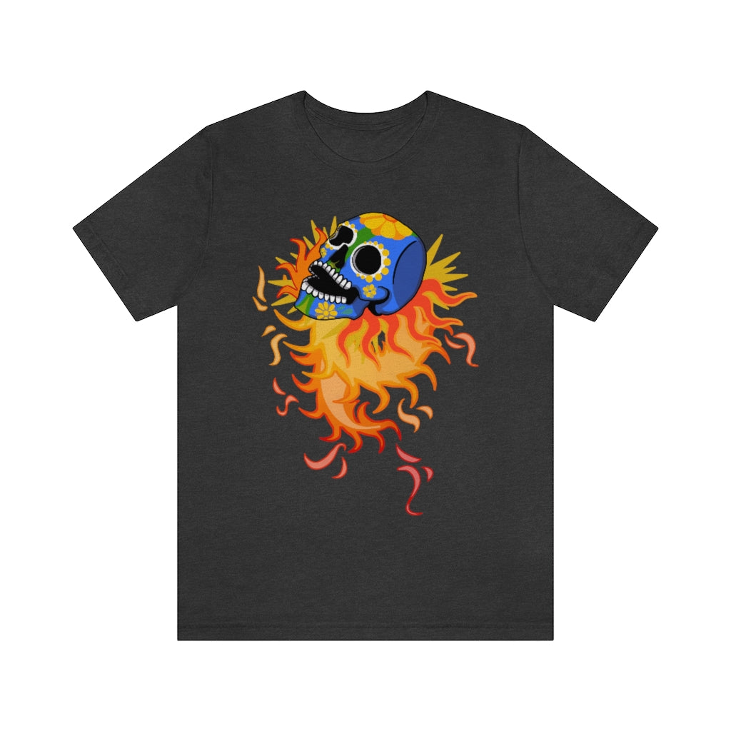 A grey T-shirt with a mexican alibrije style dia del muerte skull. It is traveling and leaves behind a spiral of fire.
