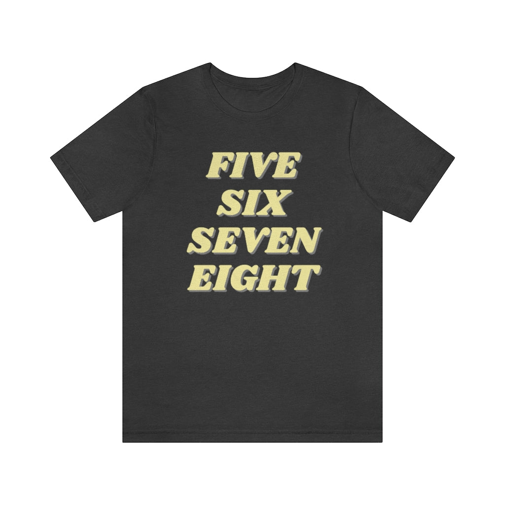 A dark grey T-shirt with the text "five sixe seven eight" in yellow text. It refers to the counting in of either music or dance.