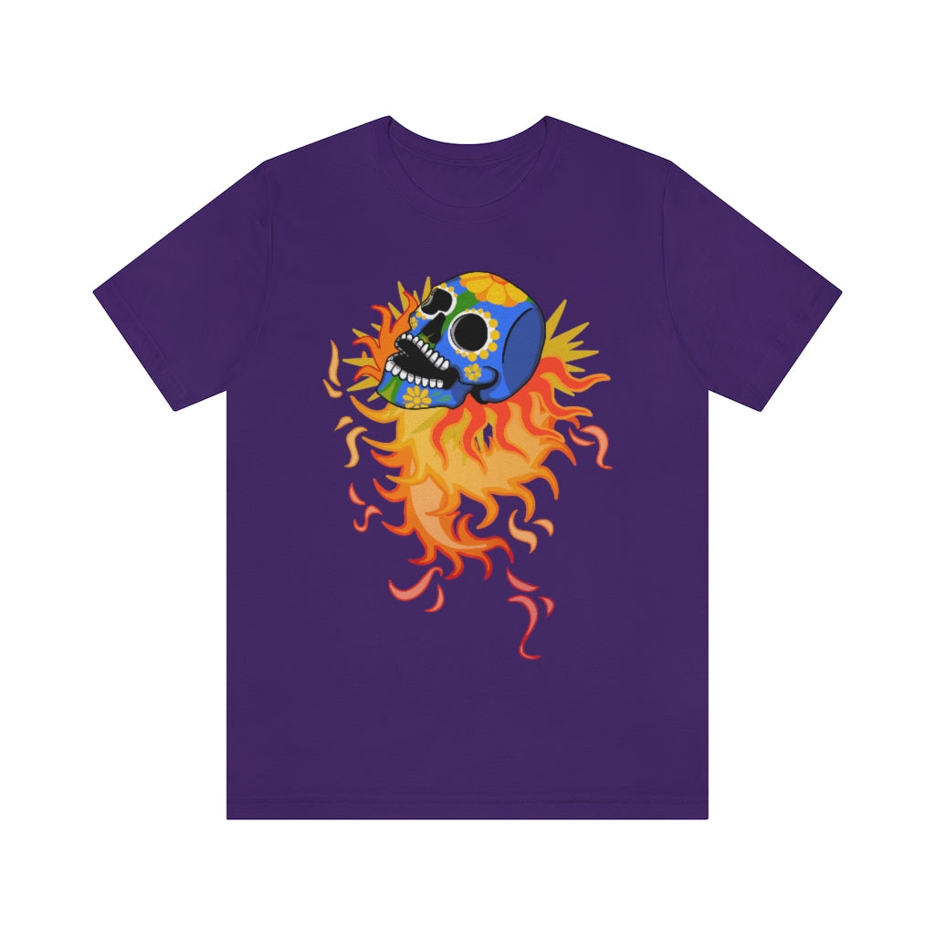 A purple T-shirt with a mexican alibrije style dia del muerte skull. It is traveling and leaves behind a spiral of fire.