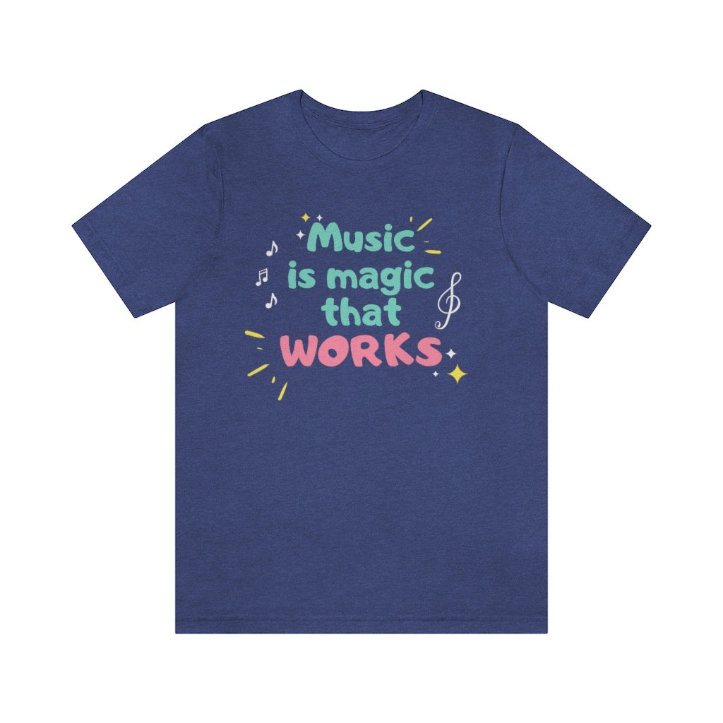 A blue T-shirt with the text "music is magic that works!". It has a childish and playful design with music notes and treble clefs surrounding it.